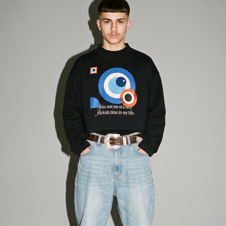 Junger Mann im Studio mit Blitz, im schwarzen Boxy Sweatshirt mit Bauhaus-Nazar-Print