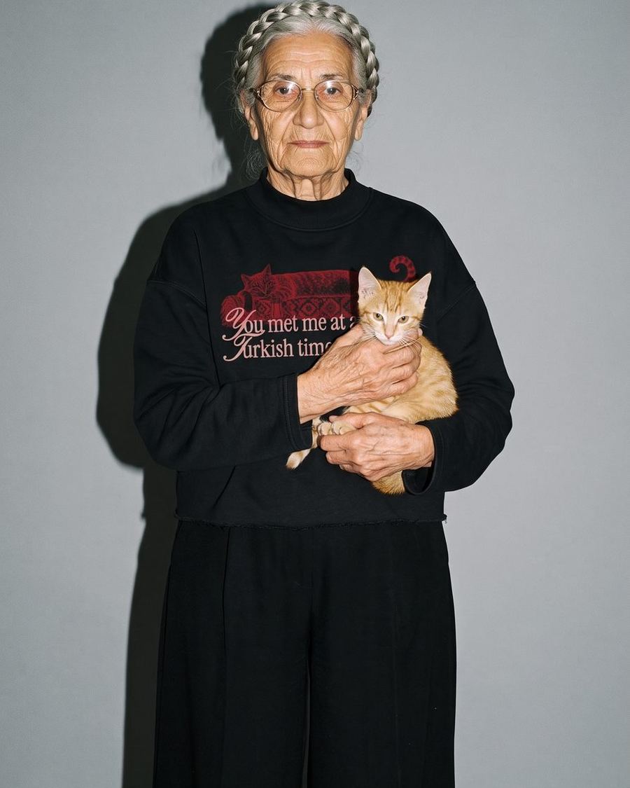 Ältere Frau mit Katze im Arm, im schwarzen Kedi-Sweatshirt