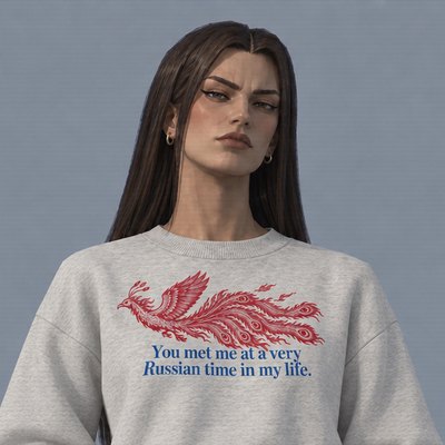 Chaya, a woman with long dark hair and winged eyeliner in the oat-grey Feuervogel sweater